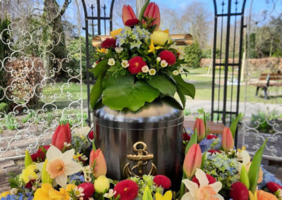 Bestattung: eine Urnenaufbahrung mit sehr vielen bunten Blumen