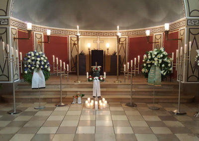 Bestattung: eine Urnenaufbahrung mit Blumen und Kerzen